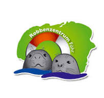 Logo of Robbenzentrum Föhr: the shape of the island of Fohr in green, with a lifesafer and two seal heads bobbing in the water in front of it.