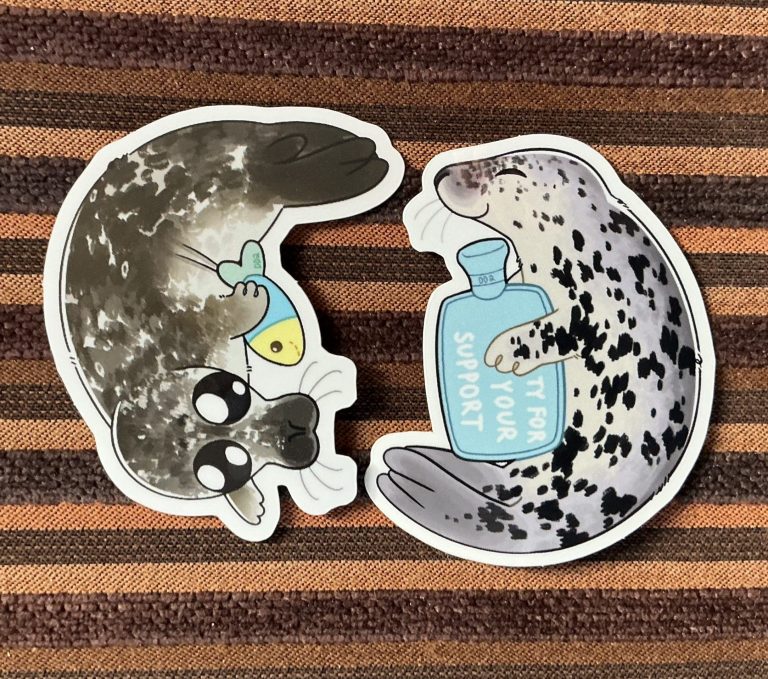 The Donation Dive stickers w33nus created - a grey seal with a hot water bottle and a wide-eyed harbor seal with a fish plushie.